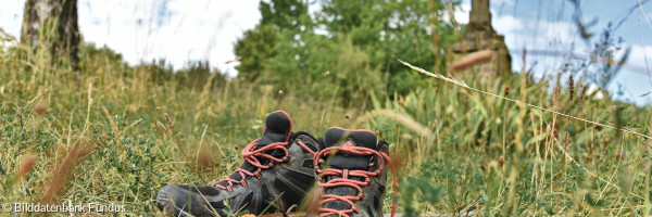 Pilgerschuhe und -stab am Kreuzweg