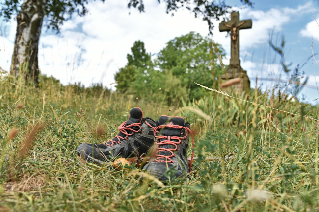 Pilgerschuhe und -stab am Kreuzweg